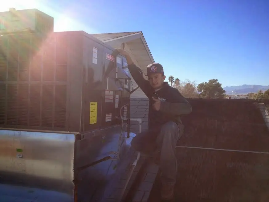 HVAC technician performing AC Tune-Up on a rooftop unit in Worth